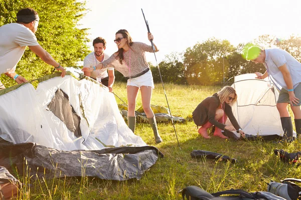 Amigos lanzando tiendas de campaña en vacaciones de camping —  Fotos de Stock