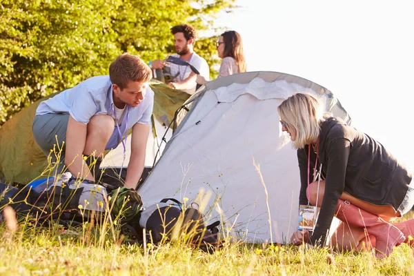 Amigos lanzando tiendas de campaña en vacaciones de camping —  Fotos de Stock