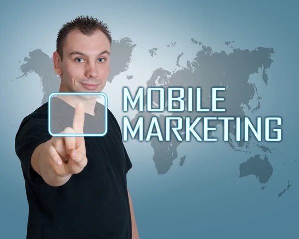 Молодой человек нажимает цифровую кнопку мобильного маркетинга на интерфейсе перед ним — стоковое фото