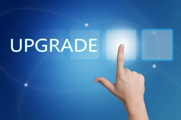 Upgrade - hand pressing button on interface with blue background. — Stock Photo, Image