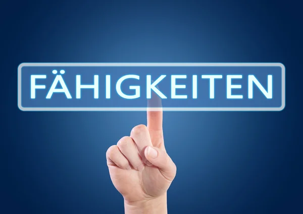 Faehigkeiten - german word for skills, ability or competence - hand pressing button on interface with blue background. — Stok fotoğraf