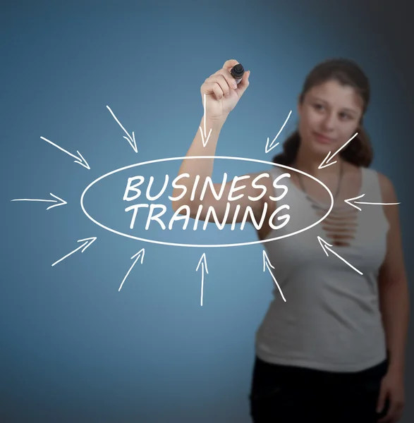 Business Training - young businesswoman drawing information concept on transparent whiteboard in front of her. — Stockfoto