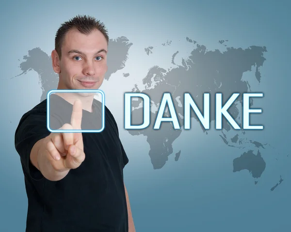 Danke - palabra alemana para agradecer - joven pulse el botón en la interfaz delante de él — Foto de Stock