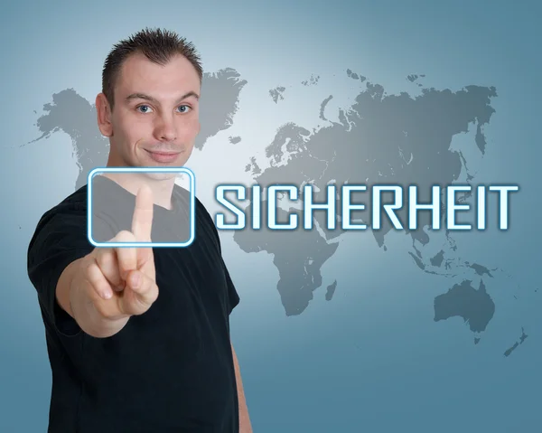 Sicherheit - Duitse woord voor veiligheids- of beveiligingsoverwegingen - jongeman druk op de knop op de interface voor hem — Stockfoto