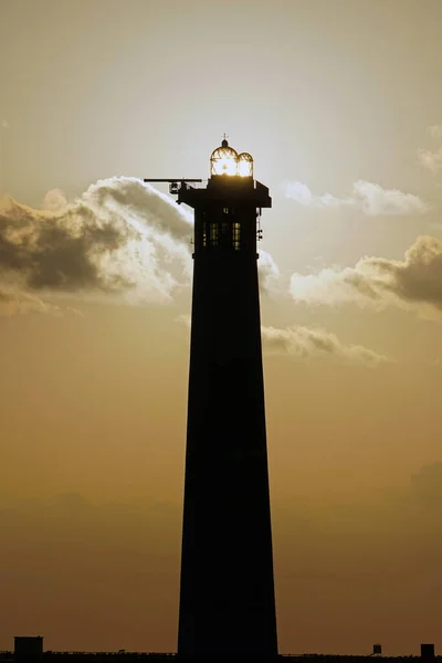 夕阳西下的灯塔对着大海的落日 — 图库照片