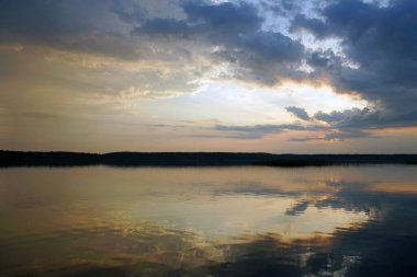   Temmuz 'da yaz akşamı. Sıcak bir günün ardından gölün üzerinde gün batımı. Sessiz cazibe ve yansıma. Ufuk                             