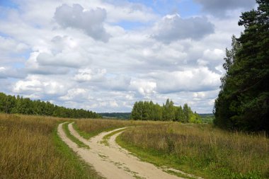 Güzel manzara. Tarladan geçen toprak yol. Nehir taşkın ovasına bakan manzara                               
