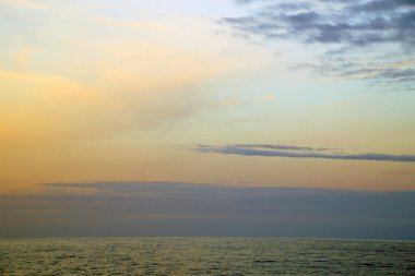     Okyanusta bir sabah. Bulutlar ve gökyüzü ufuk çizgisinde güneşin doğuşunu bekliyor.                           