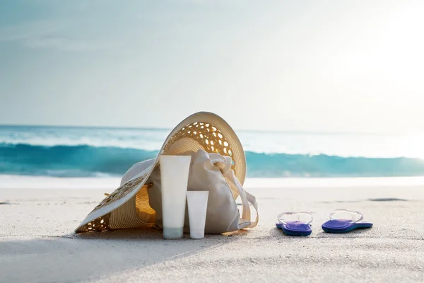 Sonnencreme, Hut mit Tasche am tropischen Strand — Stockfoto