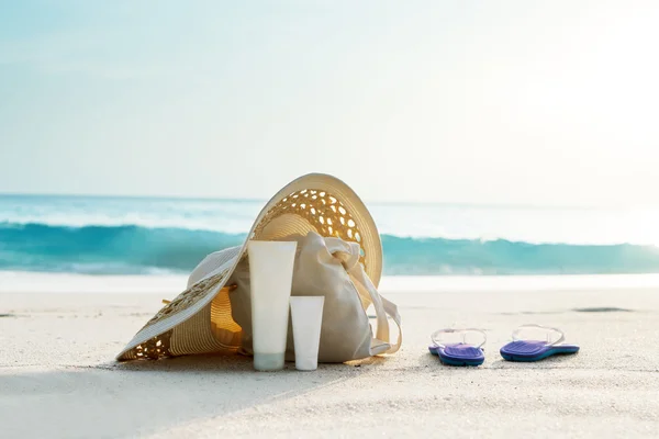 Loção solar, chapéu com saco na praia tropical — Fotografia de Stock