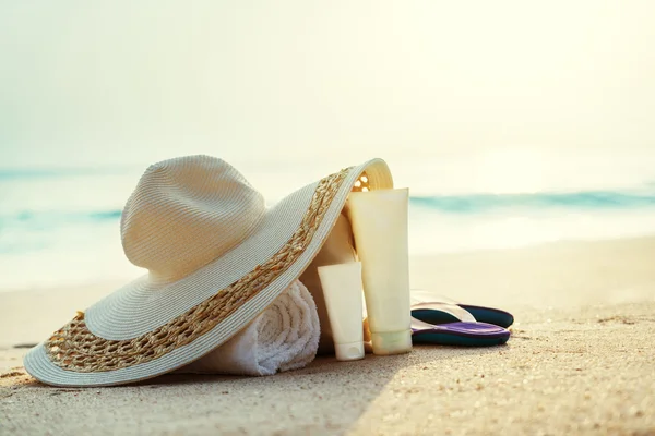 Lozione solare, cappello con borsa sulla spiaggia tropicale — Foto Stock