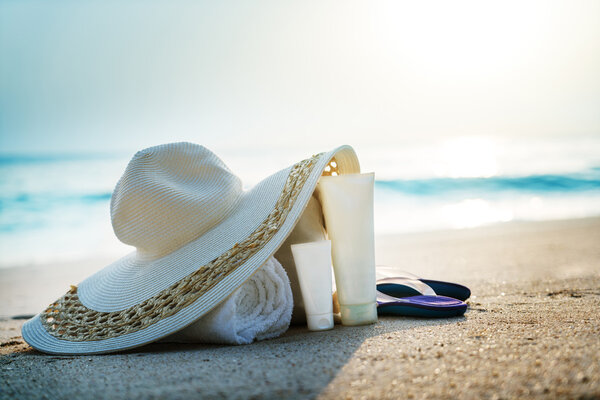 Sun lotion, hat  with bag at the tropical beach