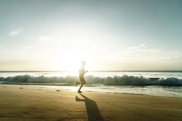 Homme courant sur la plage tropicale au coucher du soleil — Photo