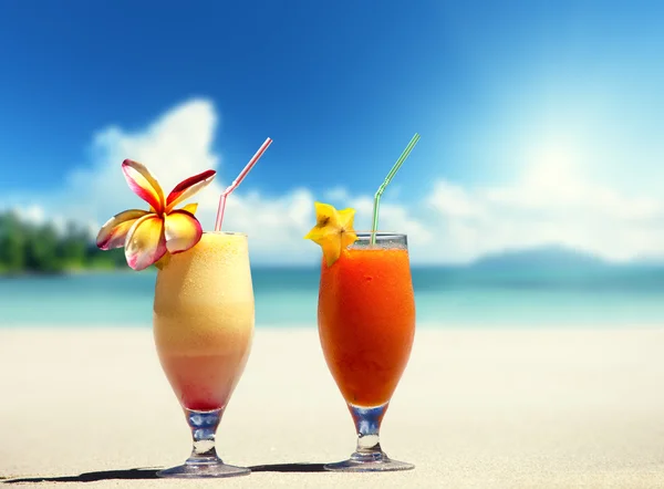 Zumos de frutas frescas en una playa tropical — Foto de Stock