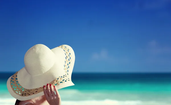 Mujer con sombrero y playa soleada — Foto de Stock