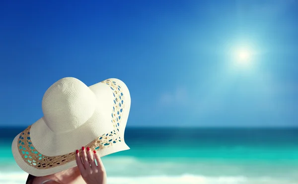 Donna con cappello e spiaggia soleggiata — Foto Stock