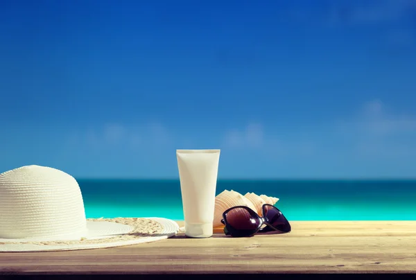 Sun lotion and sunglasses on the beach — Stock Photo, Image