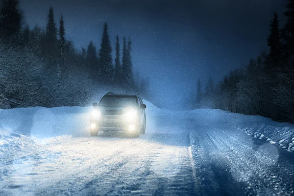 Car lights in winter forest — Stock Photo, Image