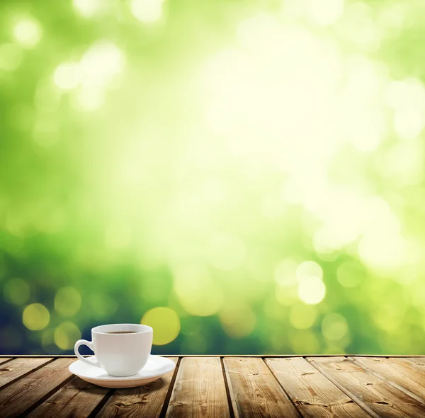 Cup coffee and sunny trees background — Stock Photo, Image