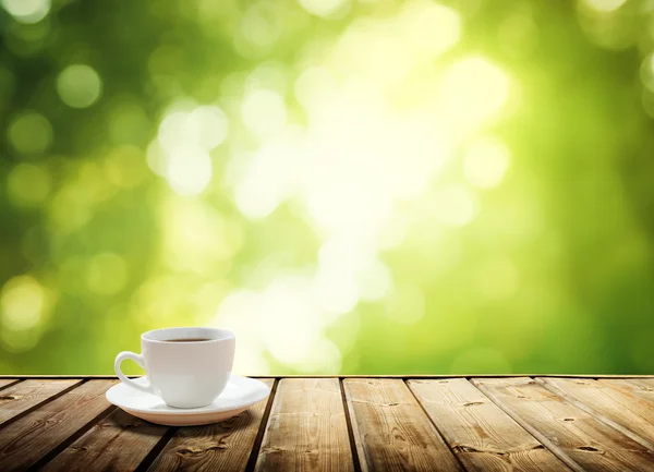 Tazza di caffè e alberi soleggiati sfondo — Foto Stock