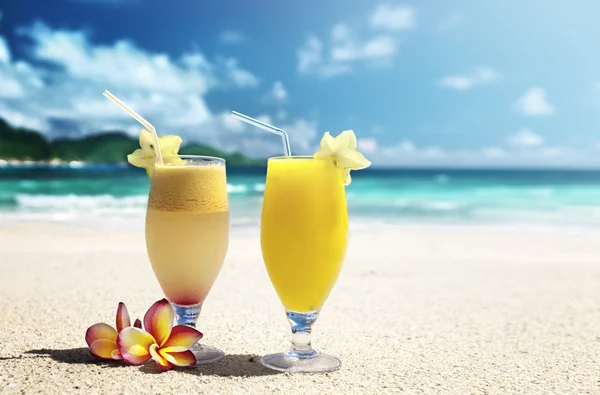 Zumos de frutas frescas en una playa tropical — Foto de Stock