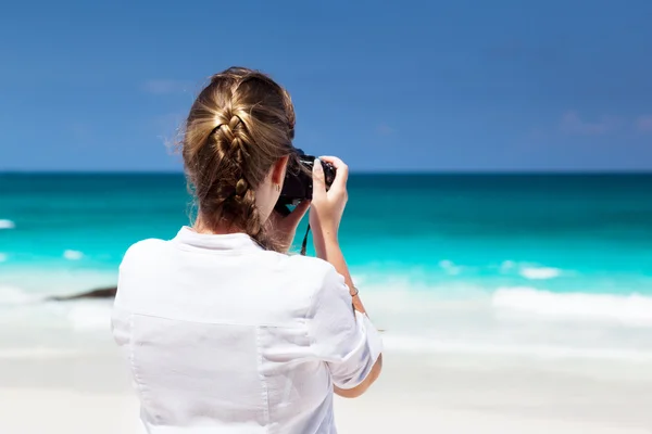 Mujer en la playa tropical tomando fotos con cámara sin espejo —  Fotos de Stock