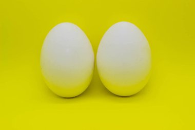 Sarı arka plan yalıtımında beyaz yumurtalar