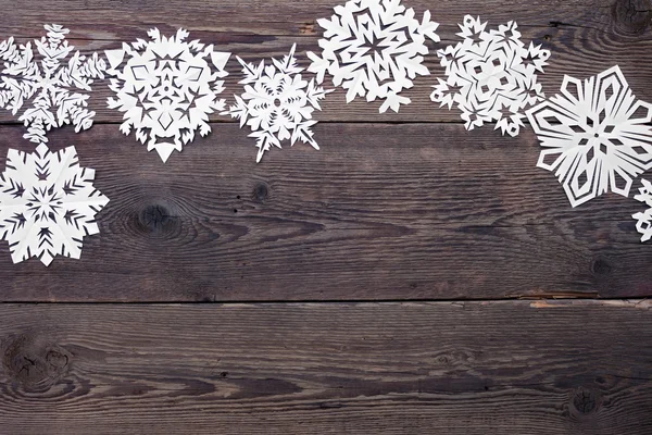 Vánoční hranice - dřevěné pozadí s sněhové vločky — Stock fotografie