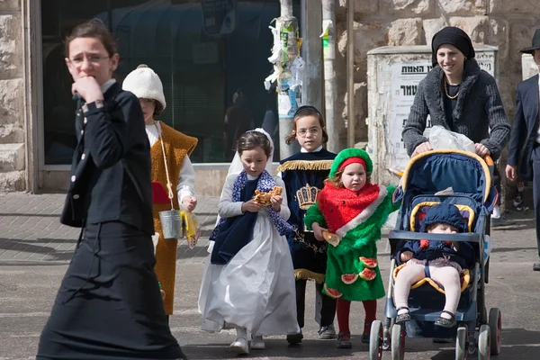 Jerusalem, Izrael - 15 marca 2006 r.: Purim karnawał. Ultra prawosławny kobieta z dzieci przez jezdnię. Dzieci przebrane w kostiumy — Zdjęcie stockowe