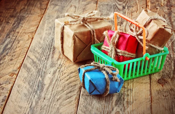 Gift boxes in plastic shopping basket — Stock Photo, Image