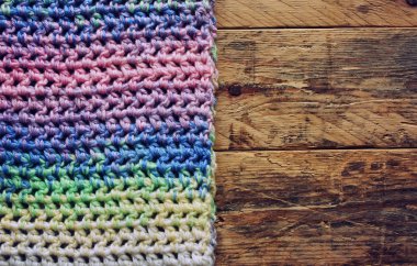 ahşap masa üzerinde renkli tığ işi atkı