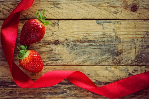 Erdbeeren und rotes Satinband — Stockfoto