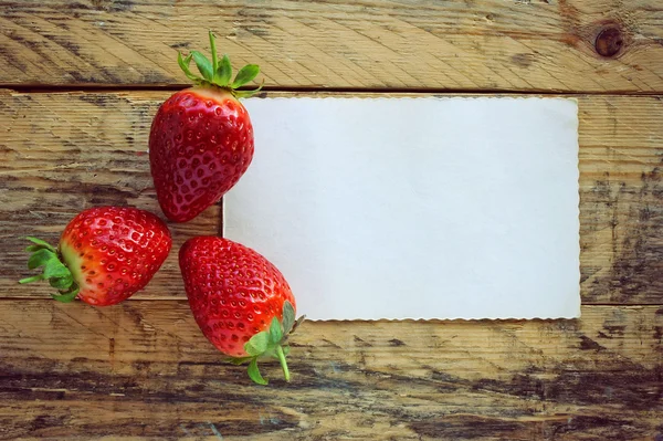 Drei Erdbeeren und leeres Papier leer — Stockfoto