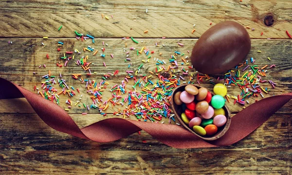 Ovo de Páscoa de chocolate com doces na mesa — Fotografia de Stock