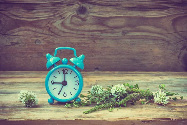 Blue retro alarm clock, summer wildflowers — Stock Photo, Image