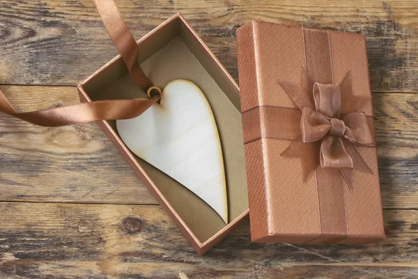 Corazón en la cinta de seda está dentro de la caja de regalo —  Fotos de Stock