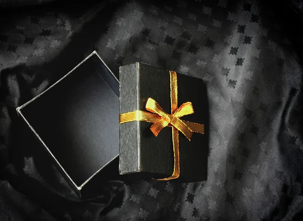 Boîte cadeau ouverte noire avec ruban doré — Photo