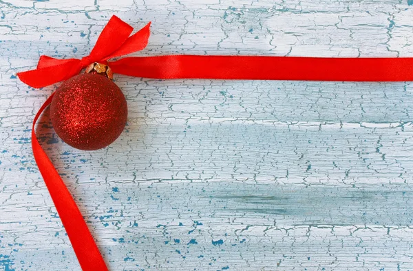 Rote Weihnachtskugel mit Seidenband — Stockfoto