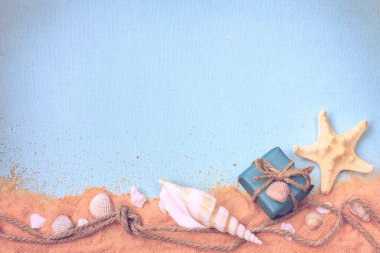 Kabuklu arka plan, kum, hediye kutusu, düğümlü ip, metin için boş alan, tatil afişi, desenli kağıt