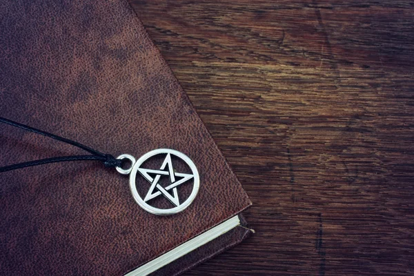 Pentagram pendant and book Stockbild