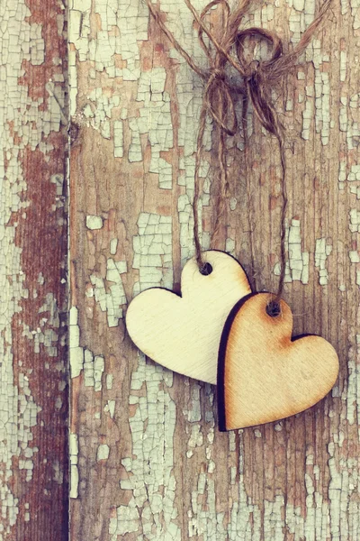 Dos corazones de madera cuelgan en un marco de ventana — Foto de Stock