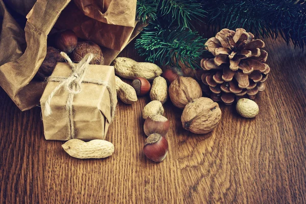 Vánoční pozadí s dar, buráky, lískové ořechy, vlašské ořechy — Stock fotografie
