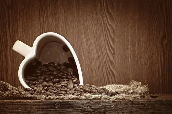 Kubek biały kształt serca z ziaren kawy — Zdjęcie stockowe