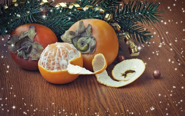 Рождественский фон с спелыми хурмами и мандарином — стоковое фото