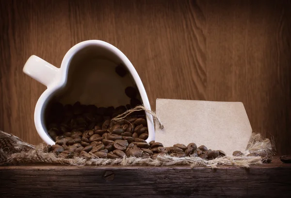 Kubek biały kształt serca z ziaren kawy — Zdjęcie stockowe
