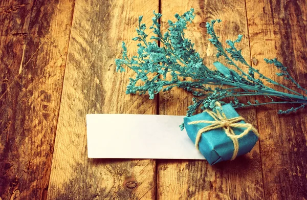 Petit coffret cadeau bleu, décor de branche, étiquette vide — Photo