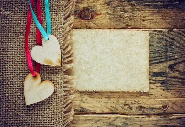 Dos corazones de madera contrachapada en cintas sobre lienzo de servilleta — Foto de Stock