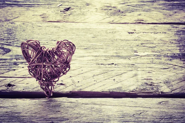 Braided wire heart on old wooden planks Royalty Free Stock Photos