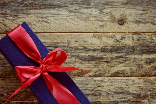 Blauwe geschenkdoos met rood lint — Stockfoto