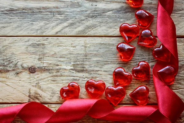 Sfondo San Valentino con nastro scarlatto, cuore di vetro — Foto Stock
